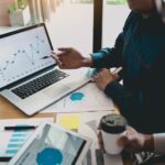 Two gentlemen are reviewing earned value graphics